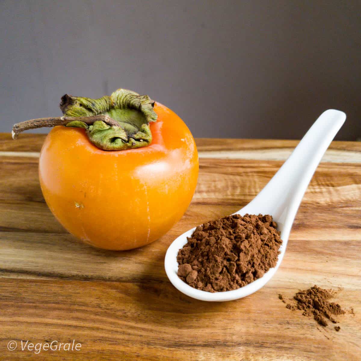 un caco intero e un cucchiaio di cacao