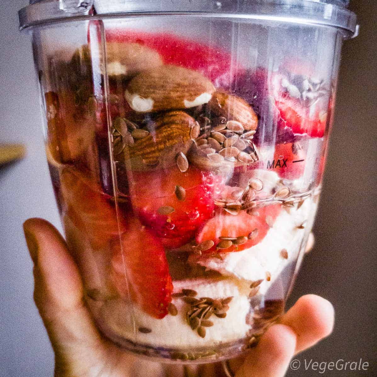 Gli ingredienti si vedono insieme all'acqua nel boccale del frullatore prima di azionarlo.