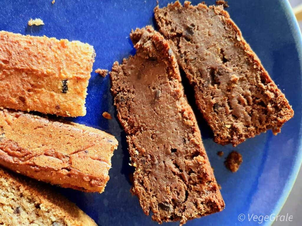 due fette di torta "brownies" al centro con a sinistra alcuni "blondies". Si nota la consistenza umida e ricca.
