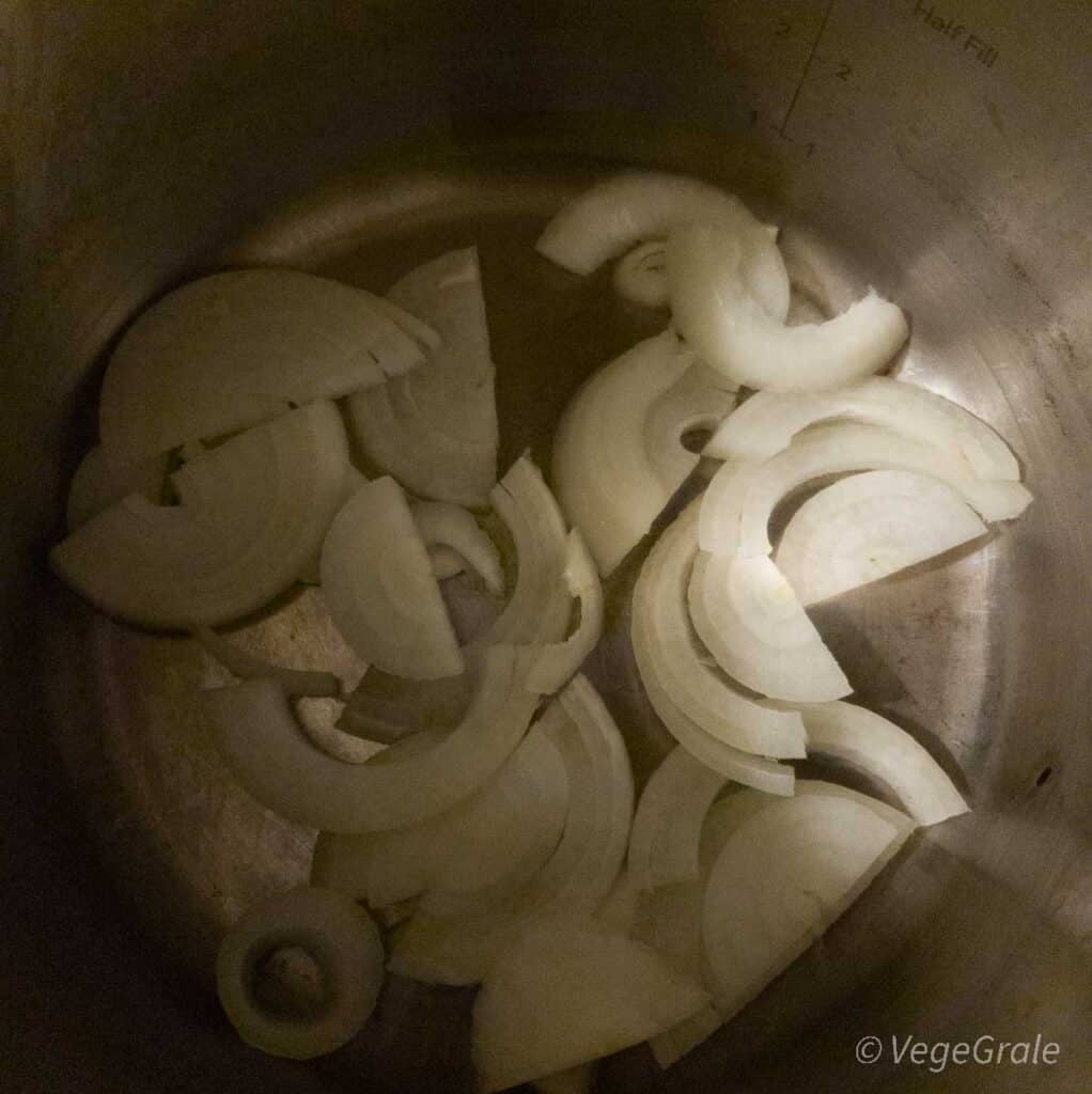 cipolla tagliata a metà e poi a fette di mezzo centimetro in pentola in acciaio inox.