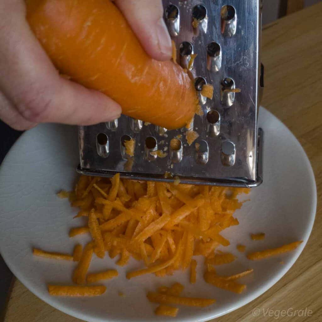 Carota grattugiata già a metà con grattugia casalinga di acciaio inox.